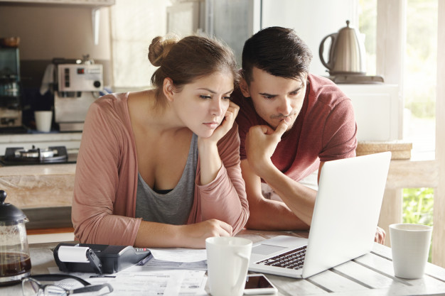 In questa foto una coppia davanti al computer intenta a far quadrare i conti del budget per il matrimonio