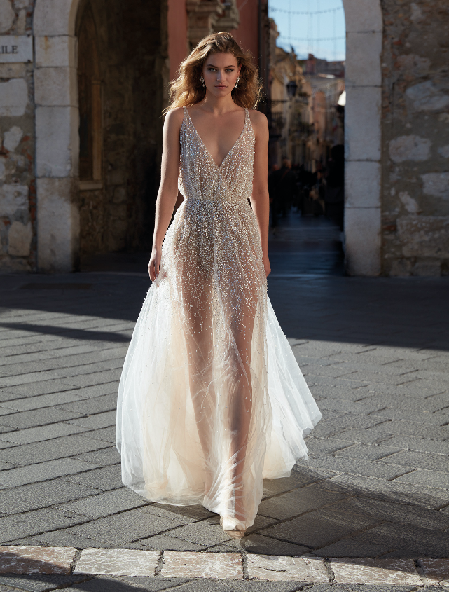 In questa foto una modella indossa un abito da sposa sparkling della collezione Nicole Milano 2021