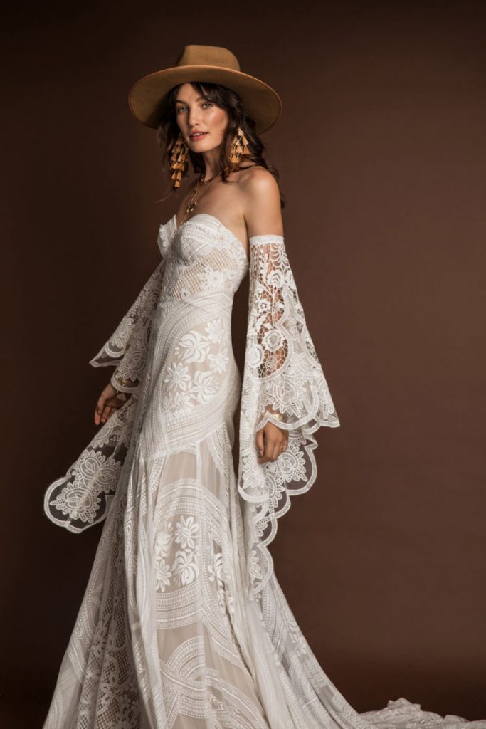 In questa foto una modella indossa un abito da sposa in stile boho perfetto per un matrimonio in primavera 