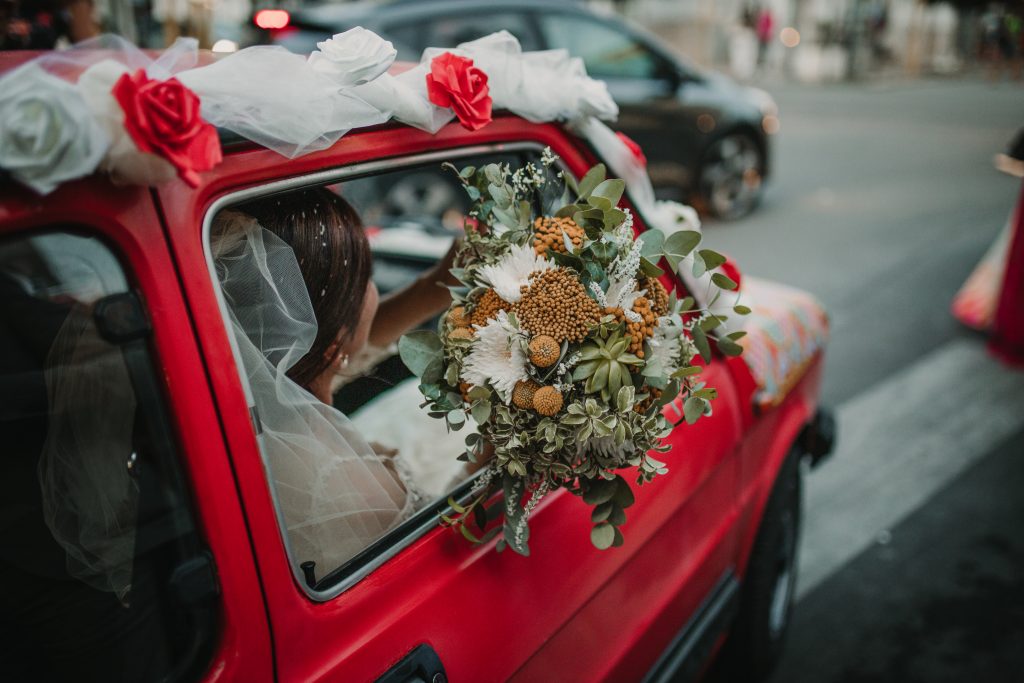 In questa foto la sposa a bordo della sua auto con il bouquet nei toni del giallo