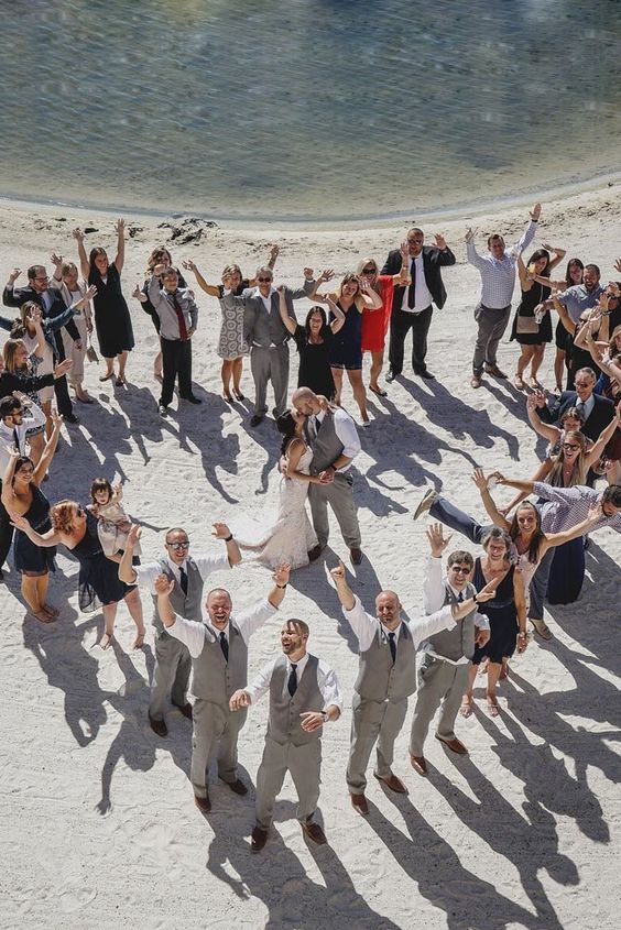 In questa foto realizzata con un drone gli invitati ad un matrimonio posano in riva ad un lago formando un cuore. Al centro gli sposi si baciano abbracciati