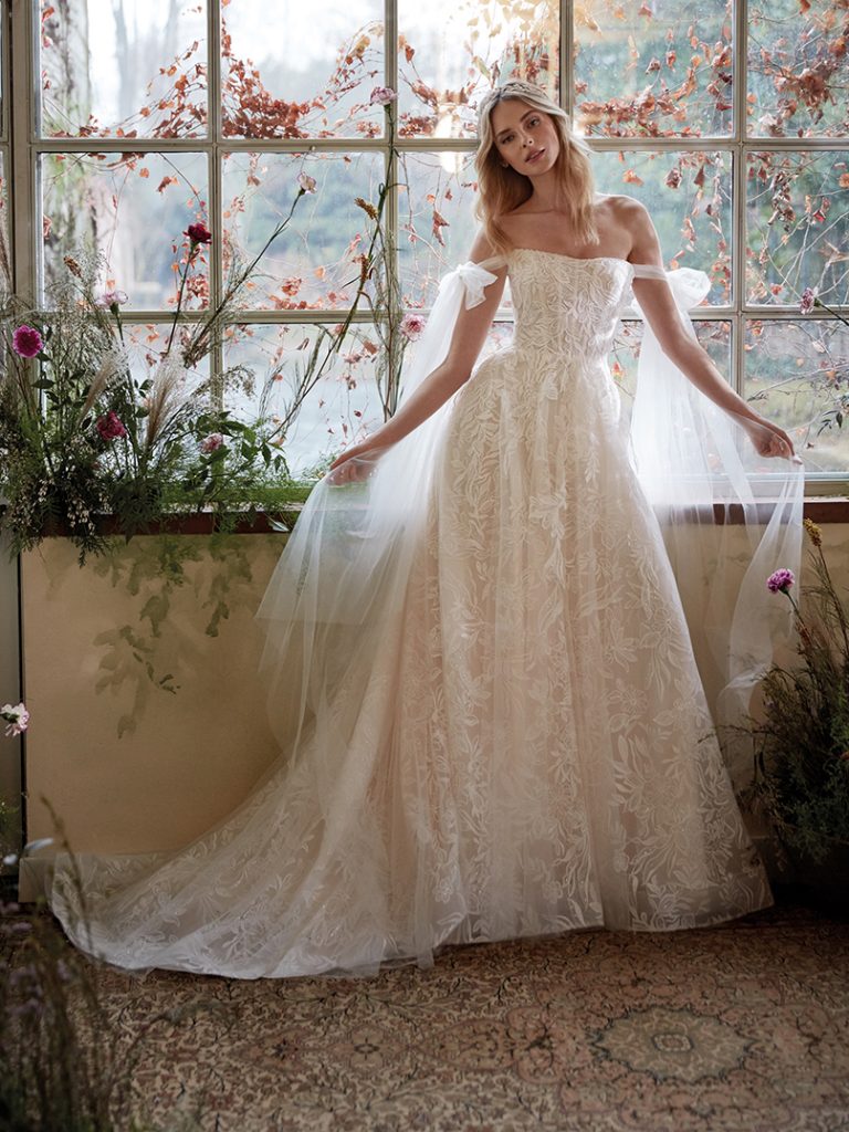 In questa foto un abito da sposa della collezione Nicole Colet 2022 con i veli che scendono dalle braccia