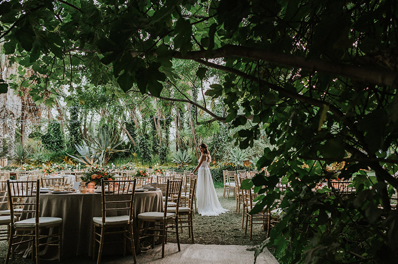 In questa foto la sposa posa tra i tavoli del ricevimento di nozze