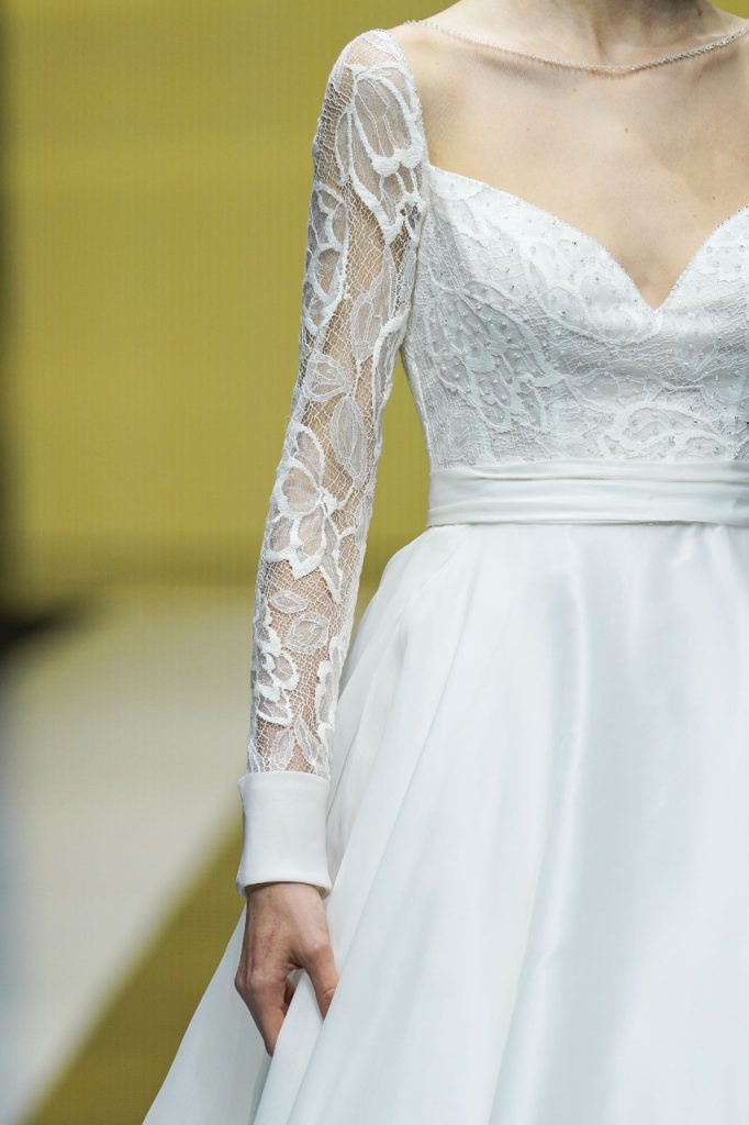 In questa foto la modella indossa un abito da sposa con maniche di pizzo.