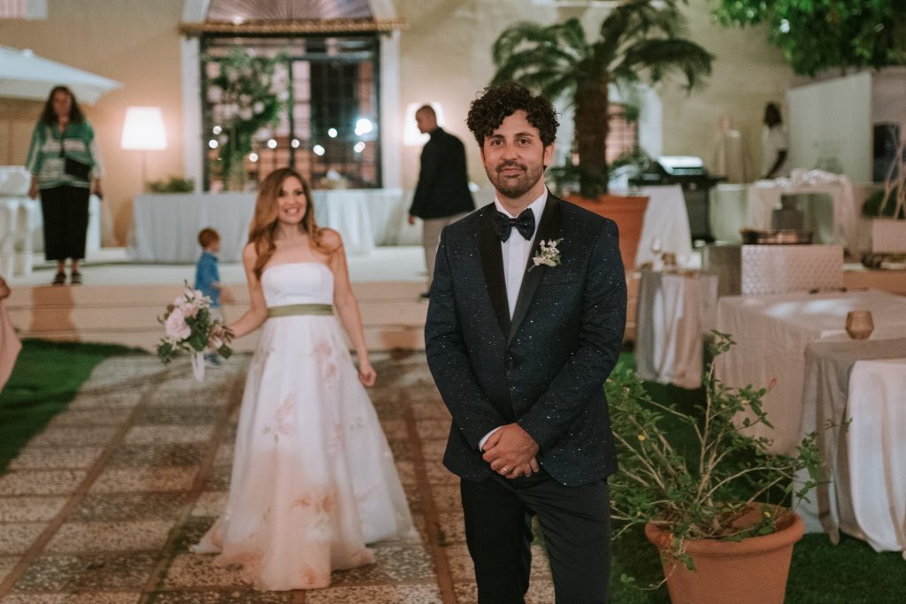 In questa foto Carlo mentre aspetta Paola dandole le spalle: la direttrice di Sposi Magazine ha scelto di fare un cambio d'abito da sposa, optando per un vestito dipinto a mano della stilista Chiara Vitale   