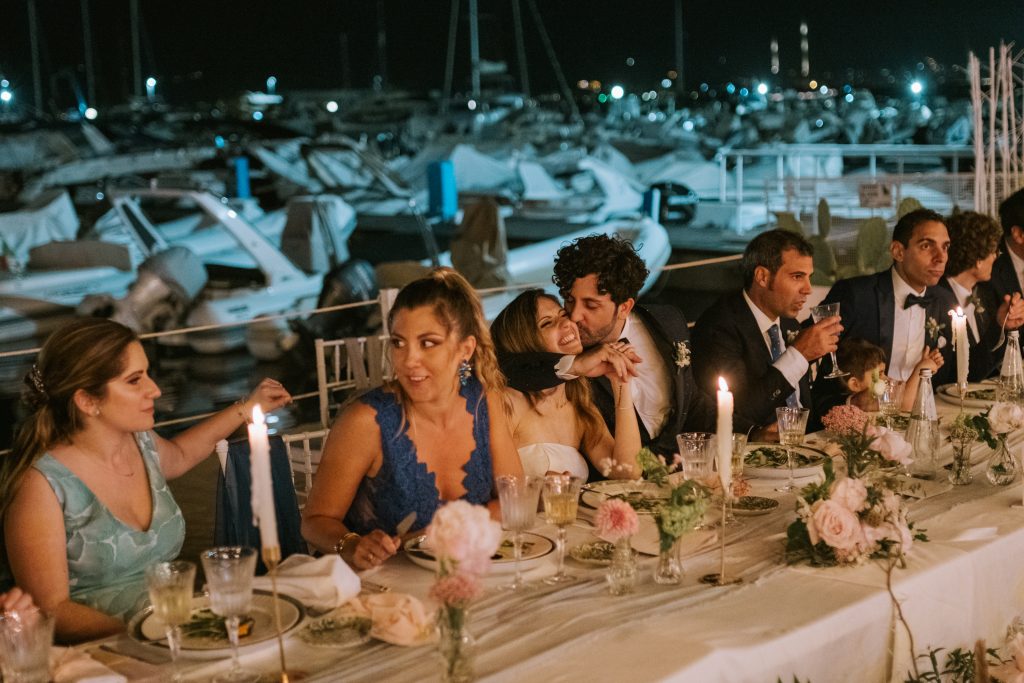 In questa foto un momento della serata del matrimonio di Paola Pizzo direttrice di Sposi Magazine: al tavolo imperiale gli sposi, intenti a baciarsi, insieme agli amici e parenti più cari