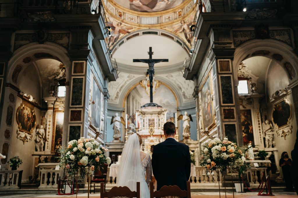 In questa foto due sposi di spalle durante la cerimonia nuziale in chiesa.