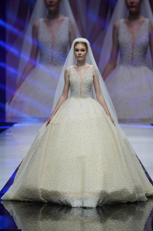 In questa foto una modella in passerella con uno degli abiti da sposa 2023 di Amelia Casablanca