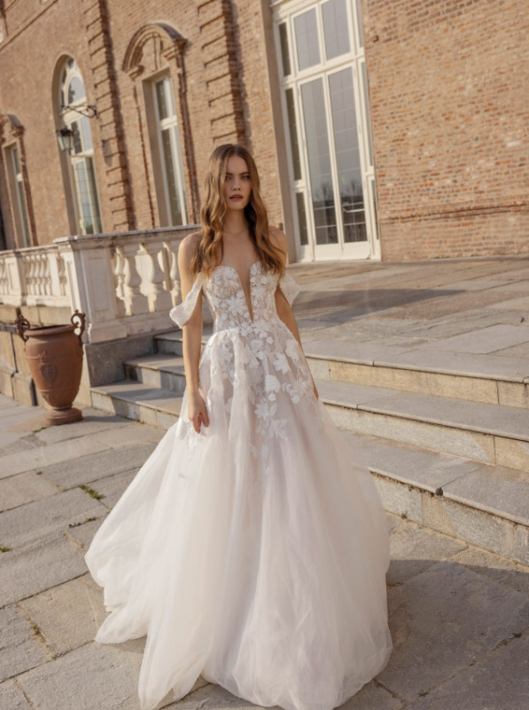 In questa foto una modella indossa uno degli abiti da sposa 2023 di Capri Sposa