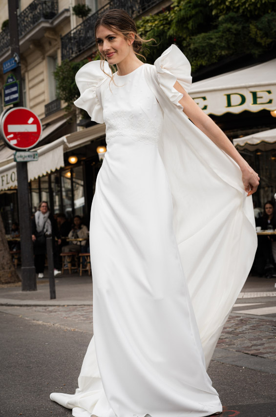 In questa foto una modella per le strade di Parigi, mentre indossa un abito minimal e total white di Cristina Tamborero 2023