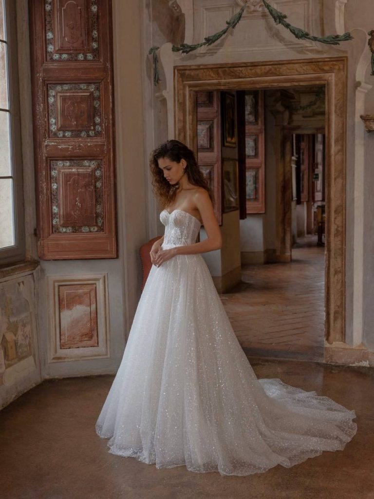 In questa foto una modella con uno degli abiti da sposa 2023 di Dominiss