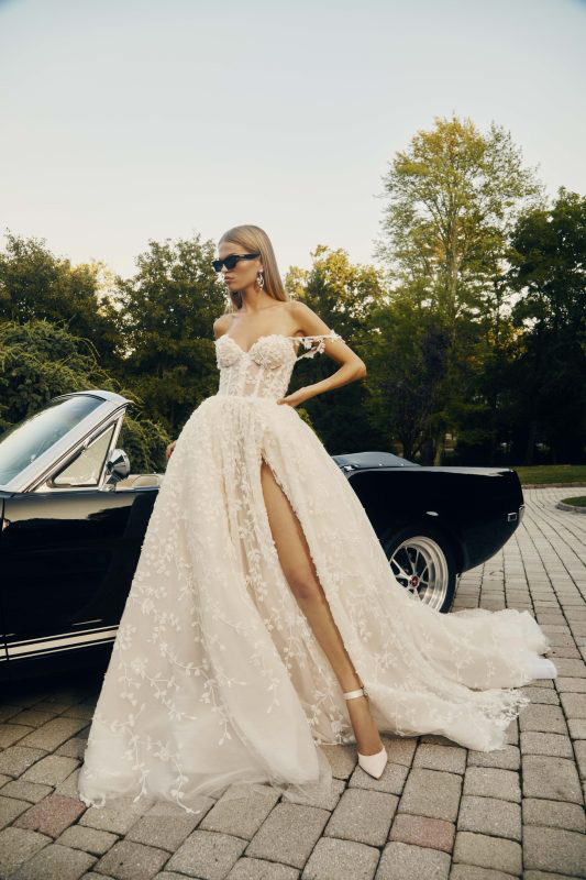 In questa foto una modella indossa un abito da sposa con spacco e bustier del brand Galia Lahav per il 2023