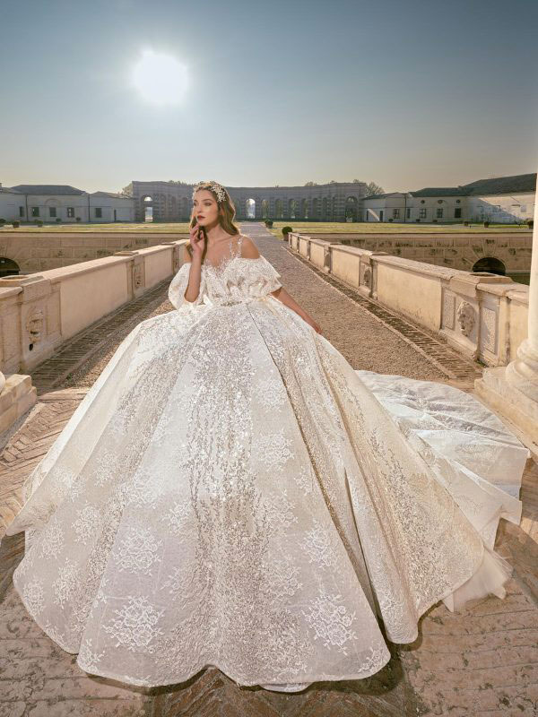 In questa foto la modella posa con un abito da sposa principessa della collezione Julia Kontogruni 2023