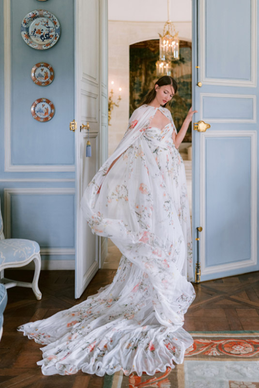 In questa foto una modella con un abito da sposa con stampa floreale a colori della collezione Monique Lhuillier 2023 