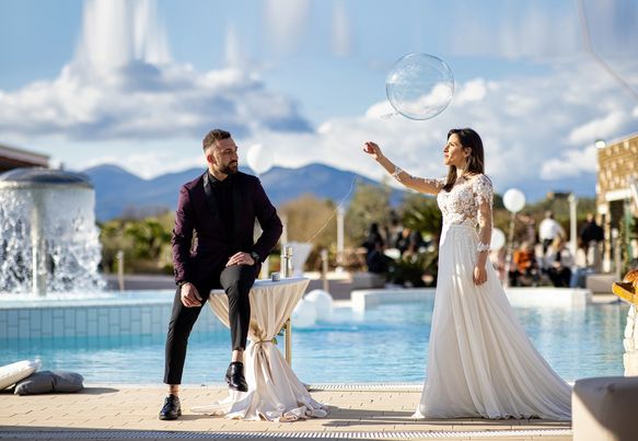 In questa foto due sposi posano a bordo della piscina di Tenuta Amalthea