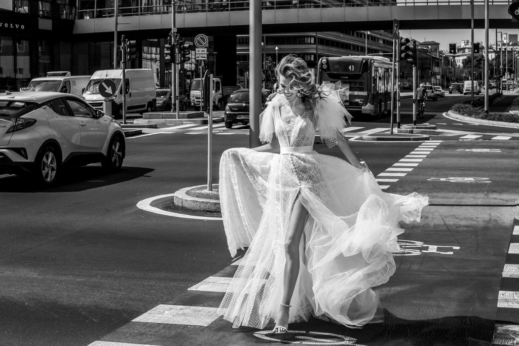 In questa immagine un abito da sposa Elisabetta Polignano 2023 con maniche in tulle e spacco profondo.