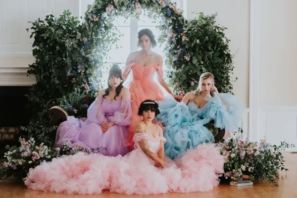 In questa foto, quattro modelle indossano abiti con gonna ampia di tulle colorato in color albicocca, glicine, azzurro e rosa
