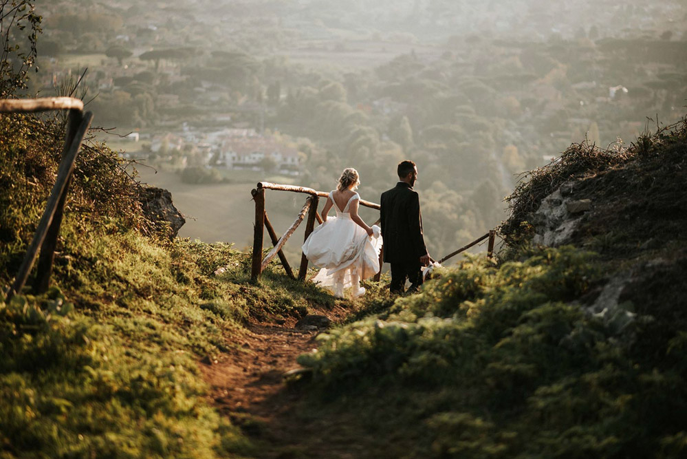 In questa foto due sposi passeggiano nella campagna durante il servizio realizzato dal fotografo di matrimonio Fabrizio Musolino