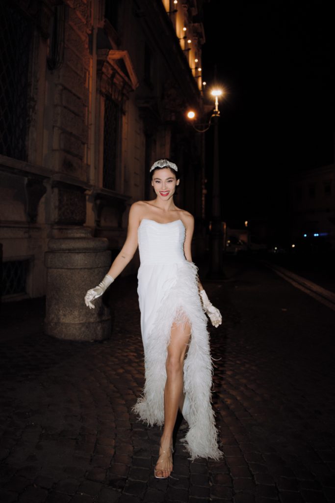 In questa immagine un abito da sposa del brand italiano con lo spacco interamente ricoperto da piume.