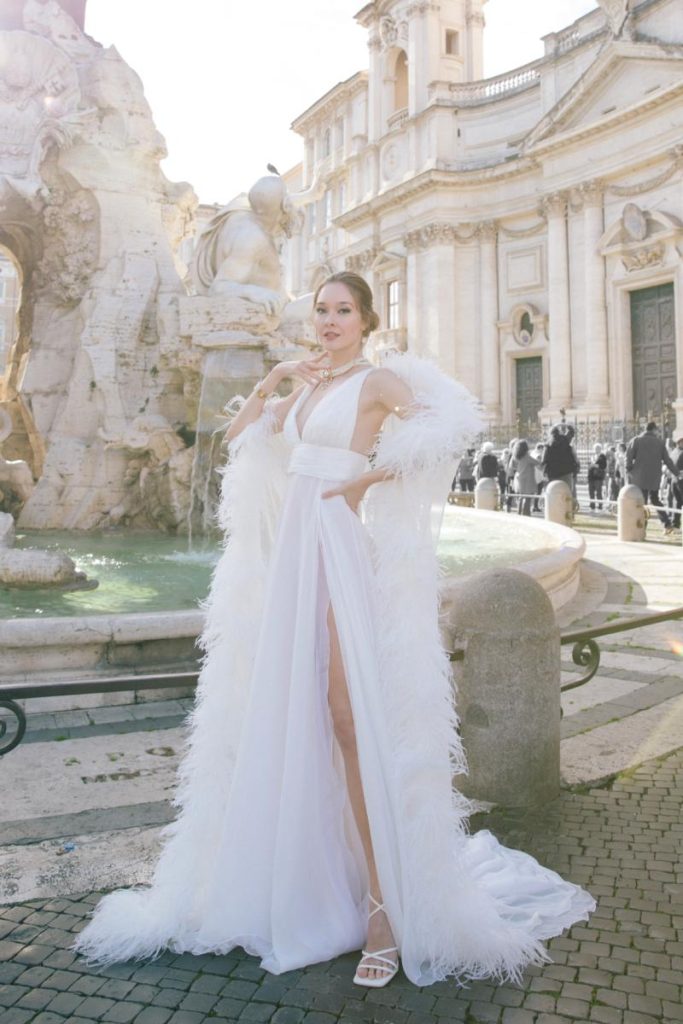 In questa immagine un abito da sposa del brand italiano con un boa in piume.