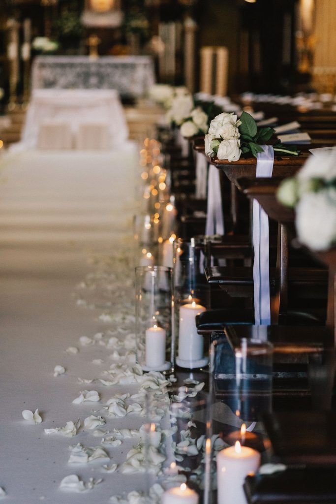 In questa foto l'allestimento della navata della Chiesa di Sant'Apollonio per le nozze di Mariavittoria e Claudio: candele profumate e petali bianchi