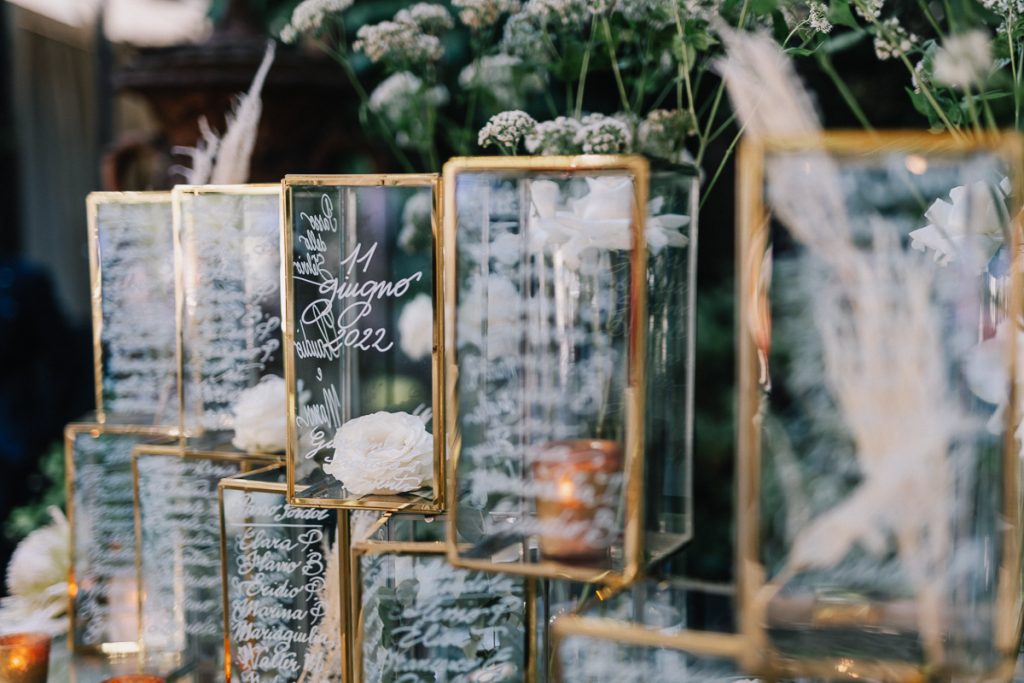 In questa foto il tableau de mariage delle nozze di Mariavittoria e Claudio preparato dalla Wedding Planner Nives Malvestiti: cilindri di vetro con scritto a mano i nomi dei tavoli e degli invitati