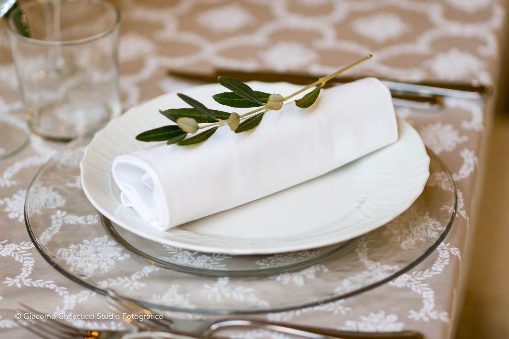 In questa foto la mise en place di un matrimonio in Toscana organizzato da Wedding by Elisa: sul piatto un ramoscello d'ulivo