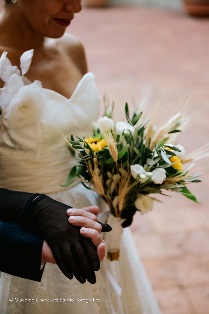 In questa foto una sposa a Castello Oliveto mentre tiene in mano il suo bouquet nel matrimonio organizzato da Wedding by Elisa