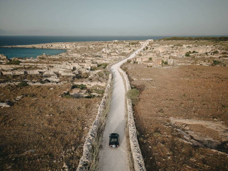 In questa una Cinquecento fotografata dal'alto su una strada di Favignana con lo sfondo del mare