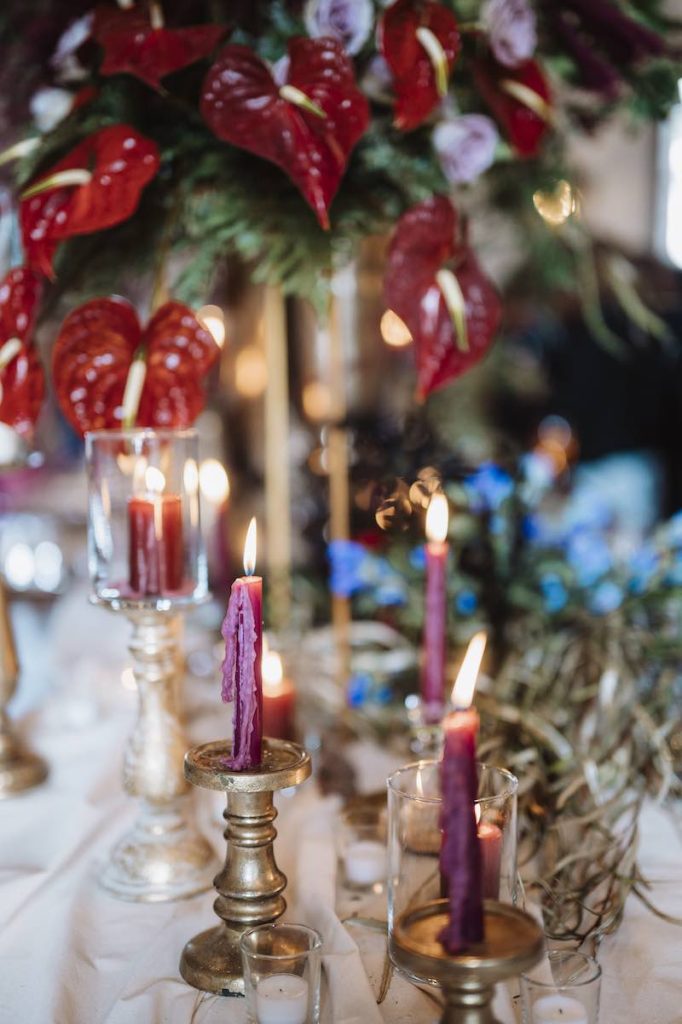 In questa foto il dettaglio di una mise en plance nel colore tema matrimonio 2023 Viva Magenta usato nelle composizioni di fiori e nelle candele posizionate in candelabri di colore oro