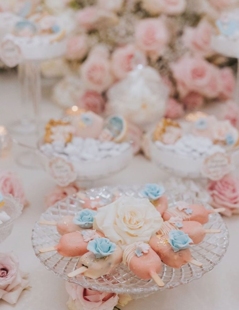 In questa foto piccoli gelati decorati con fiori 3D nei colori del rosa e del turchese in un angolo dolci di un matrimonio in stile Bridgerton