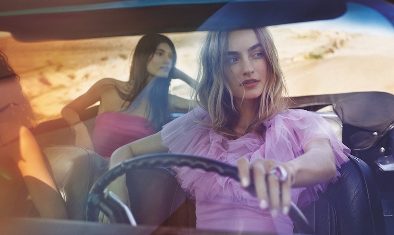In questa foto due modelle in auto mentre indossano due abiti da damigella Atelier Emé 2023 nei colori lilla e fucsia