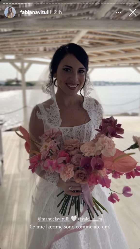 In questa immagine il matrimonio di Manuela Vitulli: la sposa posa con il bouquet super colorato