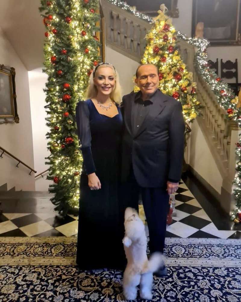 In questa foto Silvio Berlusconi con Marta Fascina e il cane Dudù posano in casa addobbata con le decorazioni natalizie