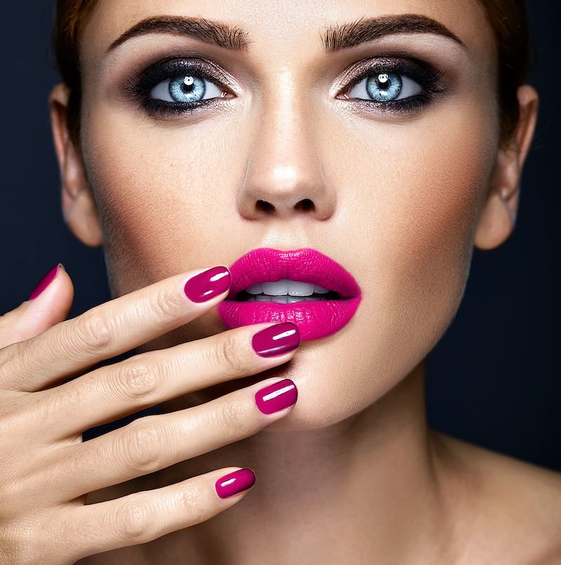 In questa foto una modella con un make up Barbiecore con rossetto di colore fucsia