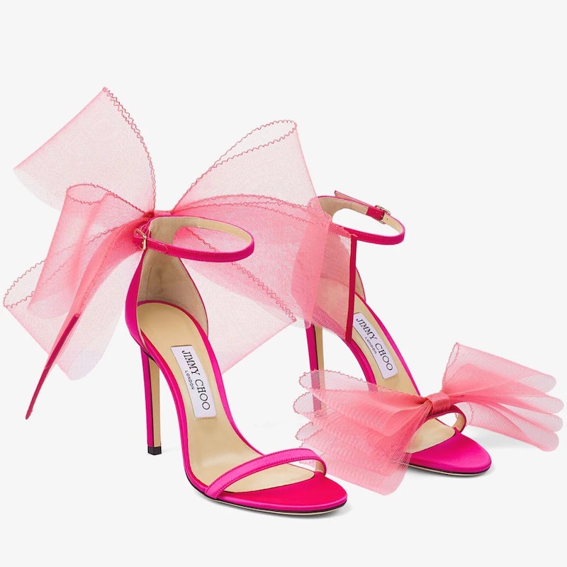 In questa foto un paio di sandali in satin di Jimmy Choo con fiocco di tulle frontale e posteriore di colore fucsia