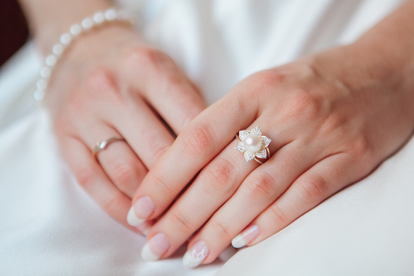 In questa foto le mani di una sposa in primo piano: indossa un anello di perla, probabilmente qualcosa di prestato secondo la tradizione dei 5 oggetti