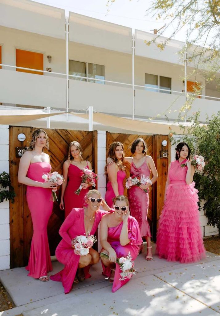 In questa foto 7 damigelle matrimonio posano indossando abiti da cerimonia fucsia di vari modelli 