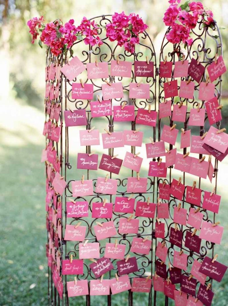 In questa foto un tableau de mariage con escort card stile Barbie di colore fucsia e rosa