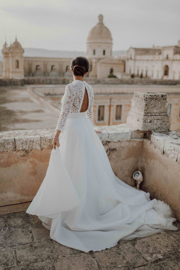 In questa immagine la sposa con indossa un meraviglioso abito con corpetto in pizzo e gonna in seta.