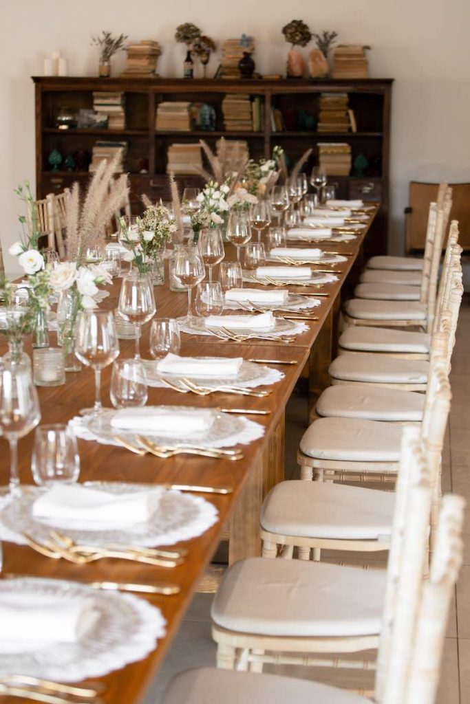 In questa foto un tavolo imperiale di legno nudo decorato con vasetti di fiori