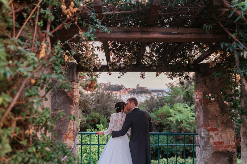 In questa foto gli sposi Clara e Jacopo si scambiano un bacio sotto il pergolato di Villa Marigola