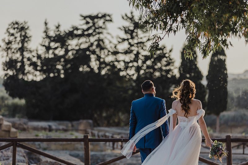 In questa foto di Alessandro Tondo due sposi camminano di spalle mano nella mano nella Valle dei Templi