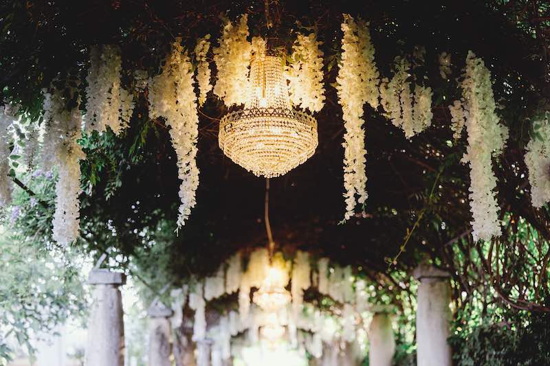 In questa foto l'allestimento del pergolato di Villa Nenni realizzato dalla Wedding Planner Benedetta Carpanzano con glicine e lampadari di cristallo