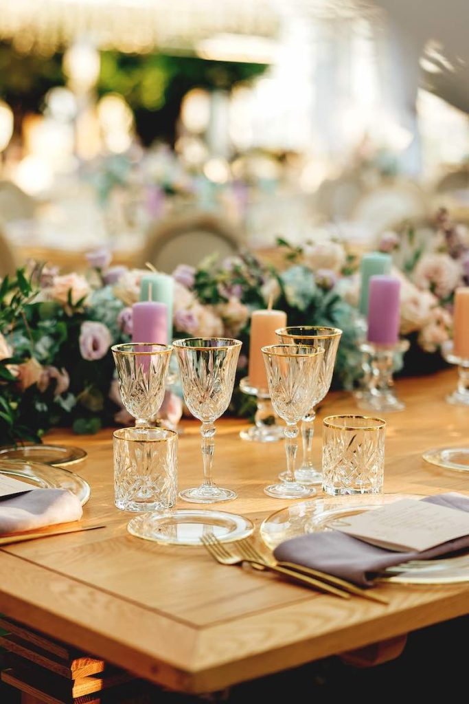 In questa foto il dettaglio della mise en place delle nozze in casa di Silvio e Giulia realizzata da Benedetta Carpanzano con bicchieri di cristallo, candele colorate e fiori