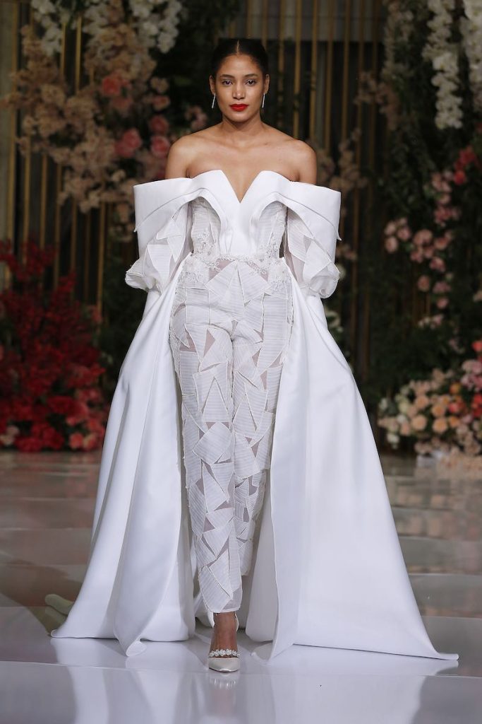 In questa foto una modella indossa una tuta da sposa 2024 di Ese Azenabor con sopragonna