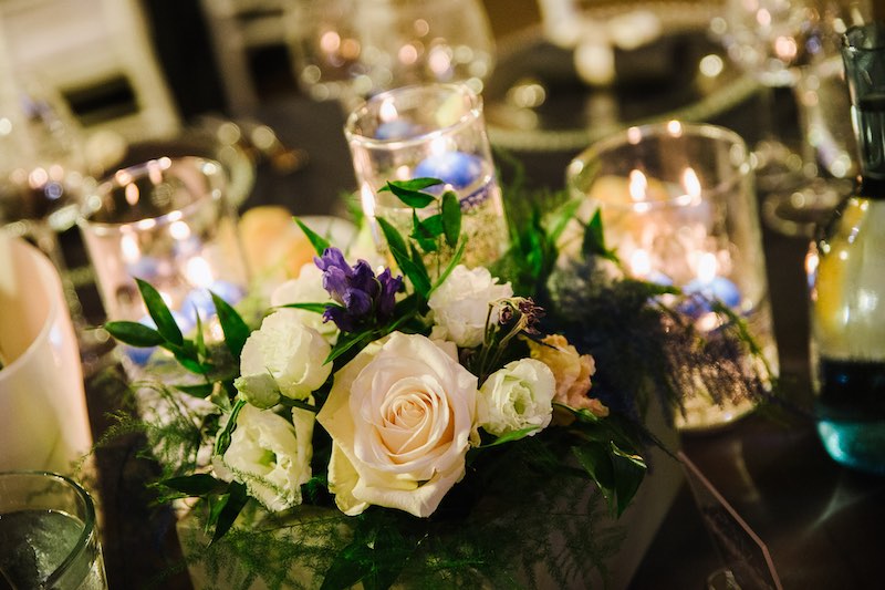 In questa foto un dettaglio della mise en place delle nozze di Elisa e Francesco sviluppata dal Wedding Planner di Michele Squeri di OttoQuattro Eventi con fiori, candele e tovagliato nei toni del blu e del bianco