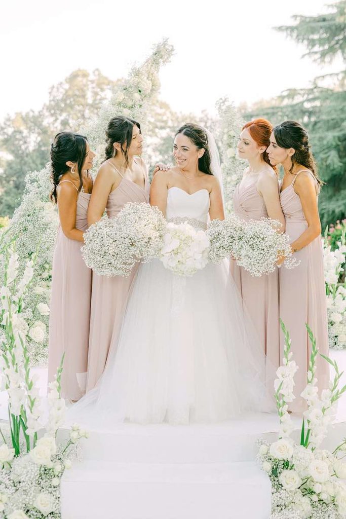 In questa foto la sposa Carlotta posa all'altare con le sua damigelle che indossano abiti colore cipria nel matrimonio organizzato da Giovanna Damonte