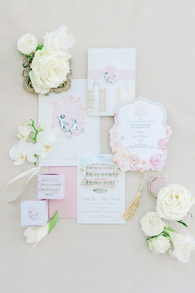 In questa la Wedding Stationery del matrimonio di Carlotta e Federico realizzata da Giovanna Damonte nei toni del bianco e del rosa con disegni realizzati ad acquerello e dettagli colore oro 