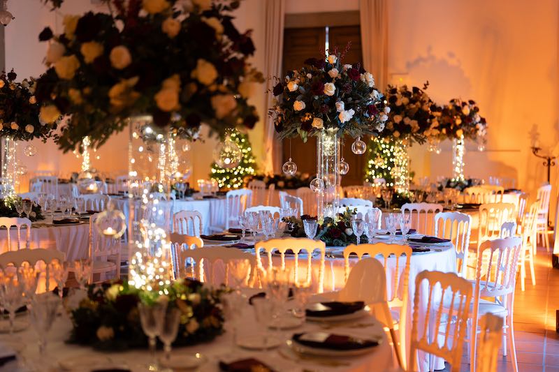 In questa foto i tavoli del matrimonio di Matteo e Pina decorati da Stefano Miranda con alzate di rose di colore rosso e bianco, lucini e sfere di vetro pendenti